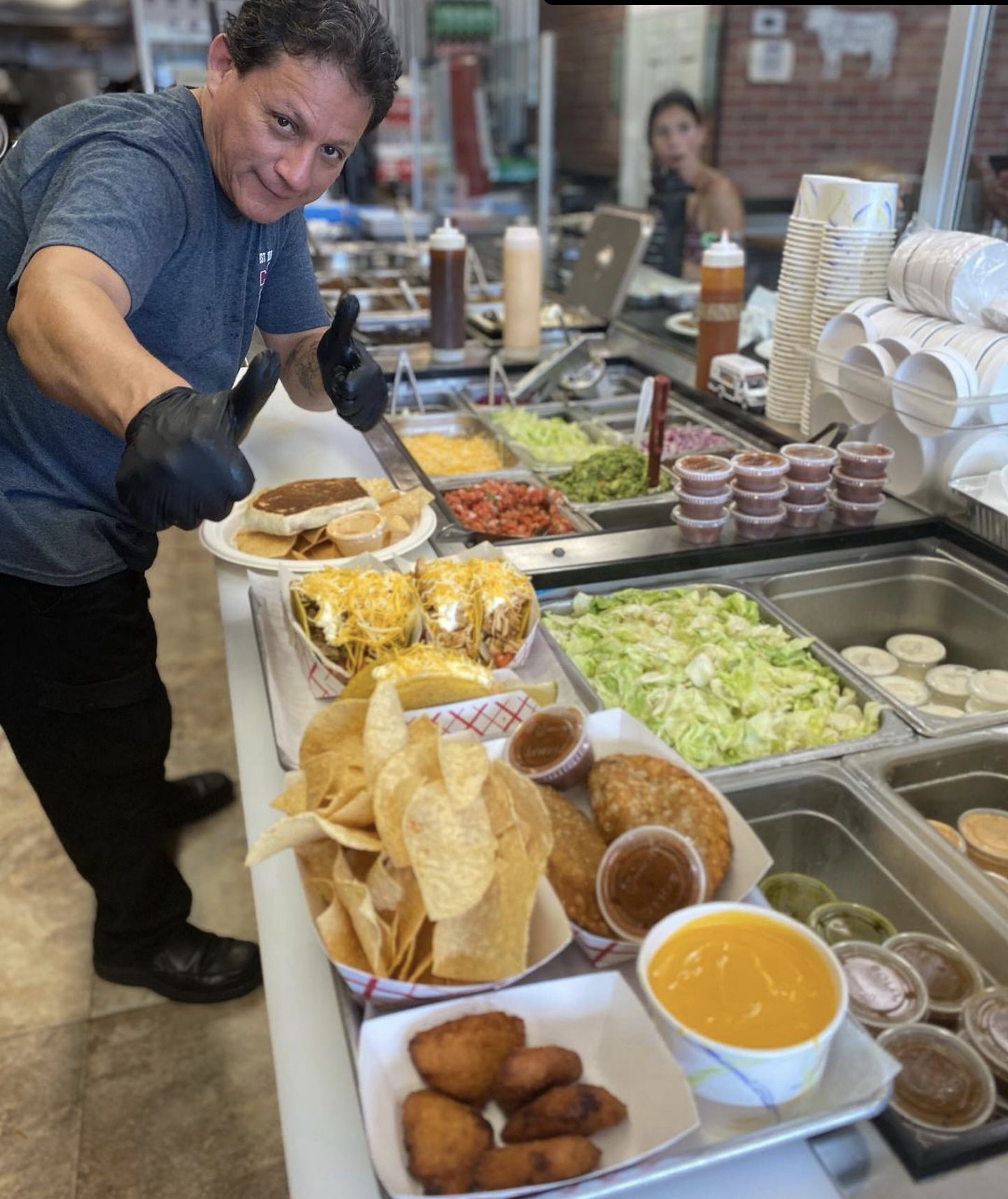 Man giving thumbs up over a row of food he just prepared